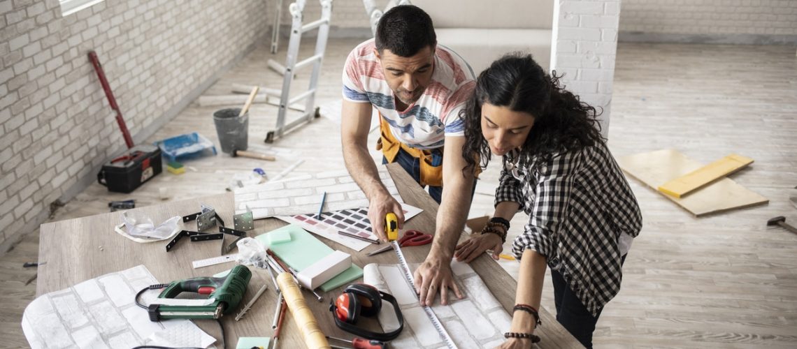 Couple making home improvement and measuring